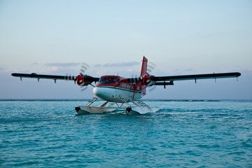Landing seaplane in the ocean lagoon. The takeoff of a seaplane at ocean beach.