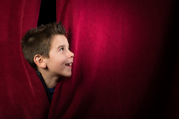 Child appearing beneath the curtain