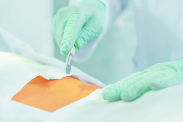 Doctor cuts with a scalpel