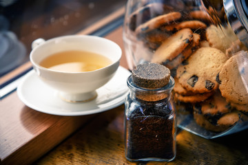 A cup of tea and chocolate chip cookies on the windowsill