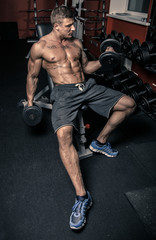 Fototapeta na wymiar Muscled man lifting weights