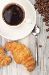 Two croissants and a cup of black coffee