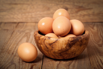 Fresh raw eggs in the wooden bowl