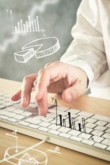 Businessman typing computer keyboard with pie chart and other in