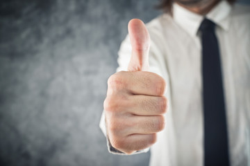 Businessman showing OK sign with his thumb up