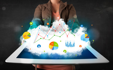 Person holding a touchpad with cloud technology and charts