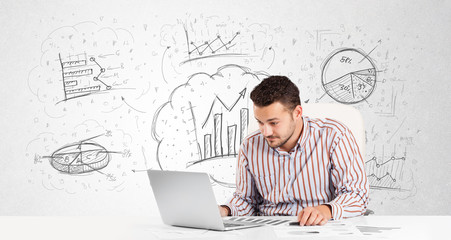 Business man sitting at table with hand drawn graph charts