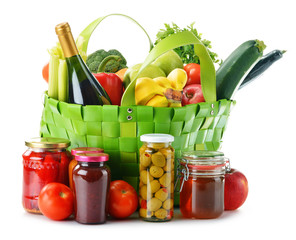 Green shopping bag with groceries isolated on white