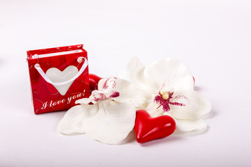 Blume mit Herz und roter Geschenkverpackung
