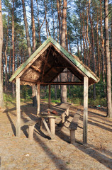Wooden gazebo in the forest.