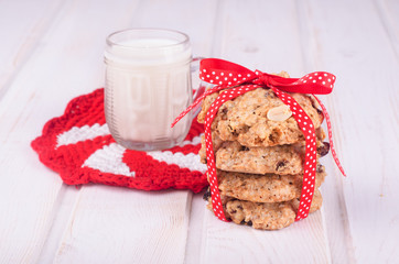 Homemade oatmeal cookies with nuts and milk with red ribbon