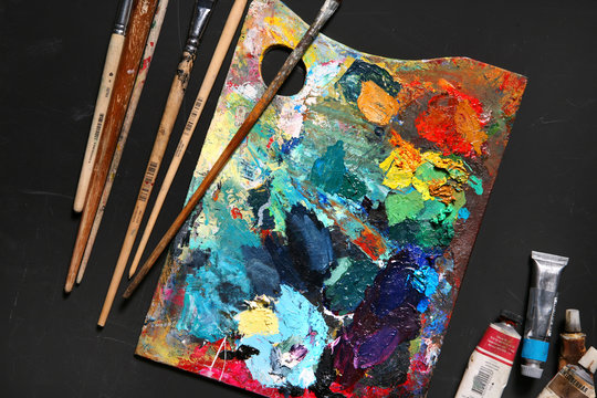 Professional brushes with palette and tubes of paint