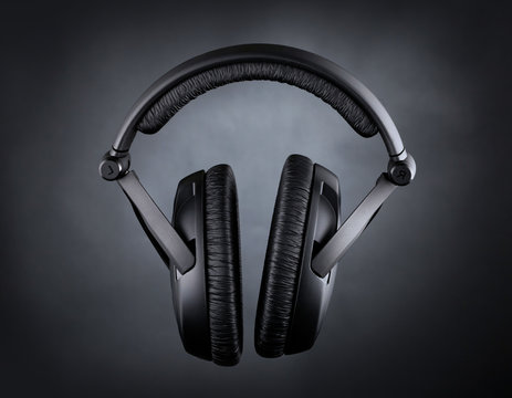 Modern headphones over black background