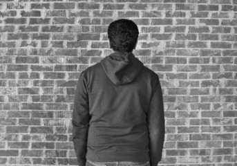 Young man with bricks wall as background,black and white