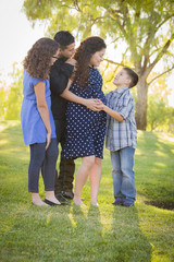 Happy Attractive Hispanic Family With Their Pregnant Mother Outd