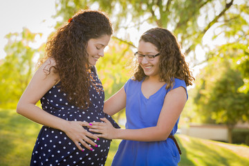 Hispanic Daughter Feels Baby Kick in Pregnant Mother’s Tummy