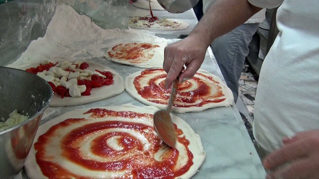 Pizza maker preparing pizza