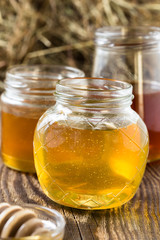 Honey in a glass jars on a wooden rustic background
