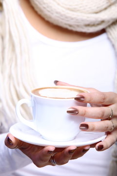 Female hands holding cup of hot latte coffee cappuccino