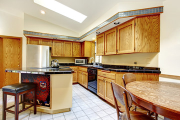 Hight vaulted ceiling kitchen with light brown storage cabinets