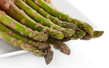 delicious fresh asparagus on a plate isolated on white