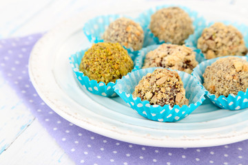 Set of chocolate candies, on plate, on wooden background