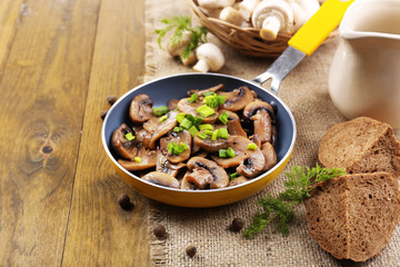 Delicious fried mushrooms in pan on table close-up