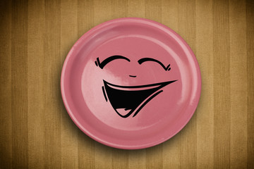Obraz premium Happy smiley cartoon face on colorful dish plate