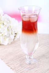 Glass of cocktail on table on light background
