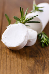 Tasty bushe cheese with rosemary, on wooden table