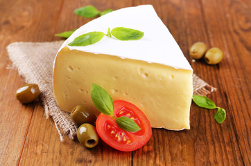 Tasty Camembert cheese with tomato, basil and olives,
