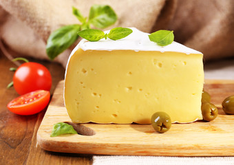 Tasty Camembert cheese with tomatoes, olives and basil,