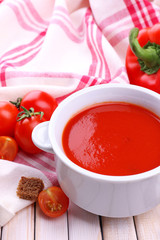 Tasty tomato soup and vegetables on wooden table