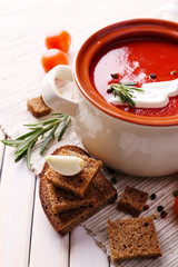 Tasty tomato soup and vegetables on wooden table