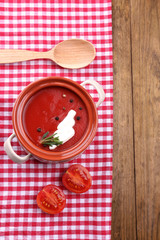 Tasty tomato soup on wooden table