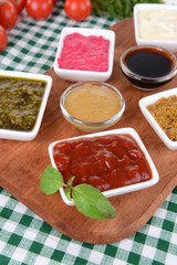 Various sauces on chopping board on table close-up
