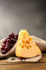 Piece of cheese with grape and rosemary