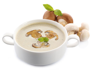Mushroom soup in white bowl, on plate, isolated on white