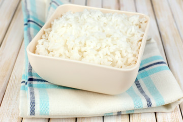 Cooked rice in bowl on wooden background