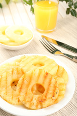 Juicy grilled pineapple on plate on table close-up