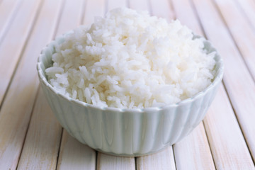 Cooked rice in bowl on wooden background