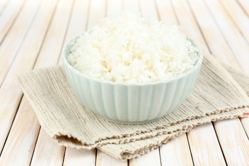 Cooked rice in bowl on wooden background