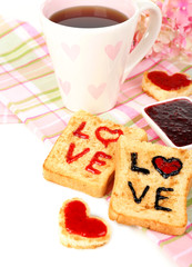 Delicious toast with jam and cup of tea on table close-up