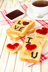 Delicious toast with jam and cup of tea on table close-up