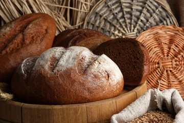 Rye bread on wooden stand on wicker background