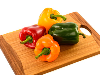 Colored bell peppers on wooden table