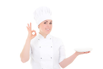 portrait of young cook woman in uniform with empty plate showing