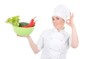 young attractive cook woman in uniform with vegetables showing o