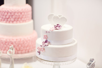 Fototapeta na wymiar Delicious wedding cake in white , creme and pink
