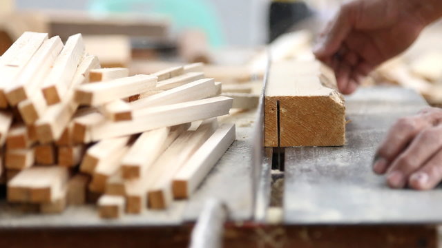 carpenter cutting wood by electric saw,no safety guard.
